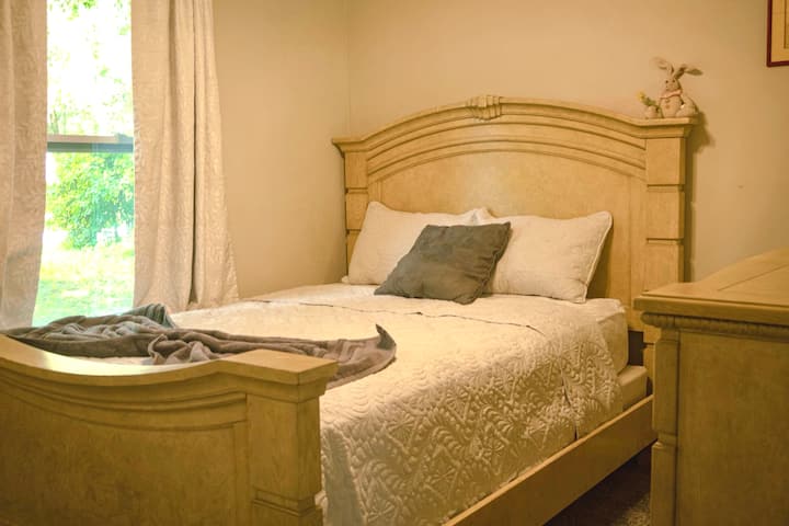 Queen-makuuhuone, jossa on pehmeät liinavaatteet rauhallista nukkumista varten.