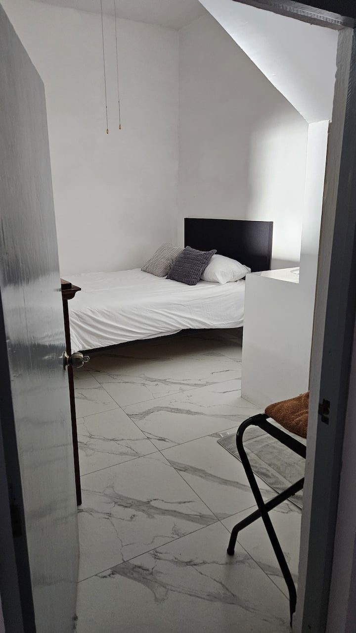 Chumba cha kulala cha ghorofa ya kwanza kilicho na kitanda cha watu wawili na bafu dogo kamili.