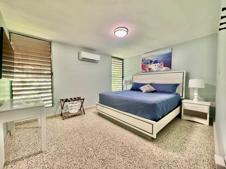 Priestranná spálňa s manželskou posteľou s dostatkom miesta na pohyb, pracovným stolom a pohodlným držiakom batožiny pre väčšie pohodlie a funkčnosť.