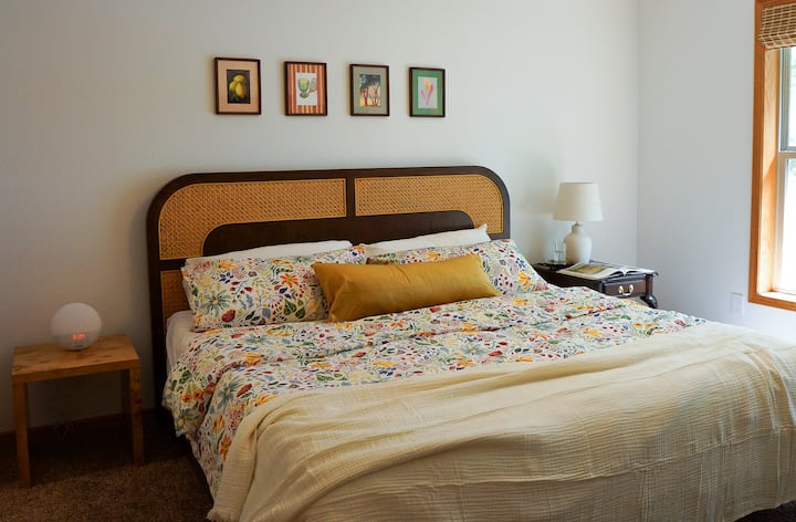 Relaksohu në një dhomë gjumi të rehatshme me një krevat dopio "king-size", shtroja me lule, televizor inteligjent 65"dhe pamje të qetë nga kopshti dhe liqeni.