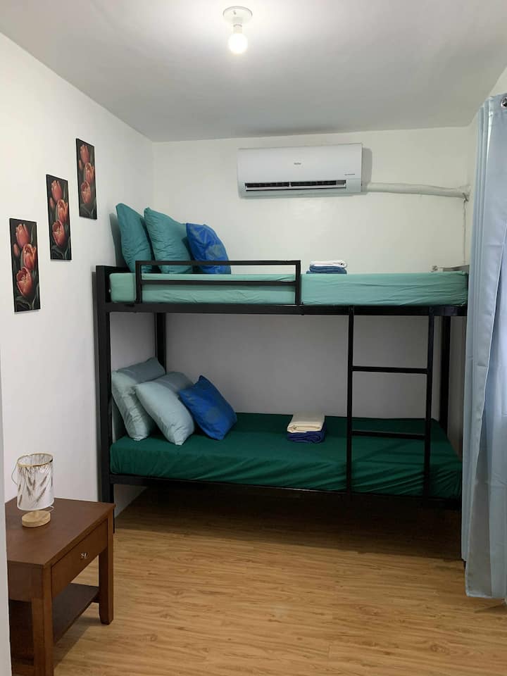 تم تصميم هذه الغرفة لتوفير الراحة والرفاهية، وتتميز بسرير بطابقين ومرتبة أرضية مزدوجة يمكن أن تستوعب ما يصل إلى 4 ضيوف. استمتع بإقامة رائعة ومريحة مع تكييف هواء كامل. "