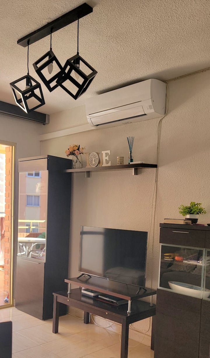 Ovaj udoban dnevni boravak odiše mirom i udobnošću. Neutralne boje, elegantni zidni ukrasi i mekani jastuci stvaraju toplu i romantičnu atmosferu. Prostrana blagovaonica s elegantnim drvenim stolom savršena je za večeru uz svijeće. 