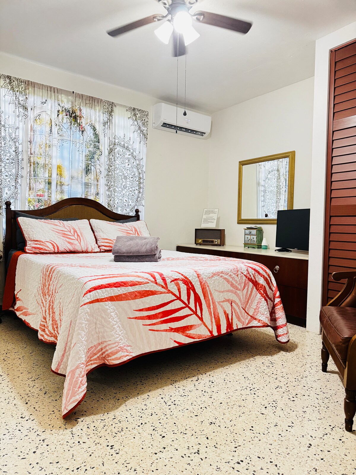 Queensize bed in hoofdslaapkamer met airconditioning en tv