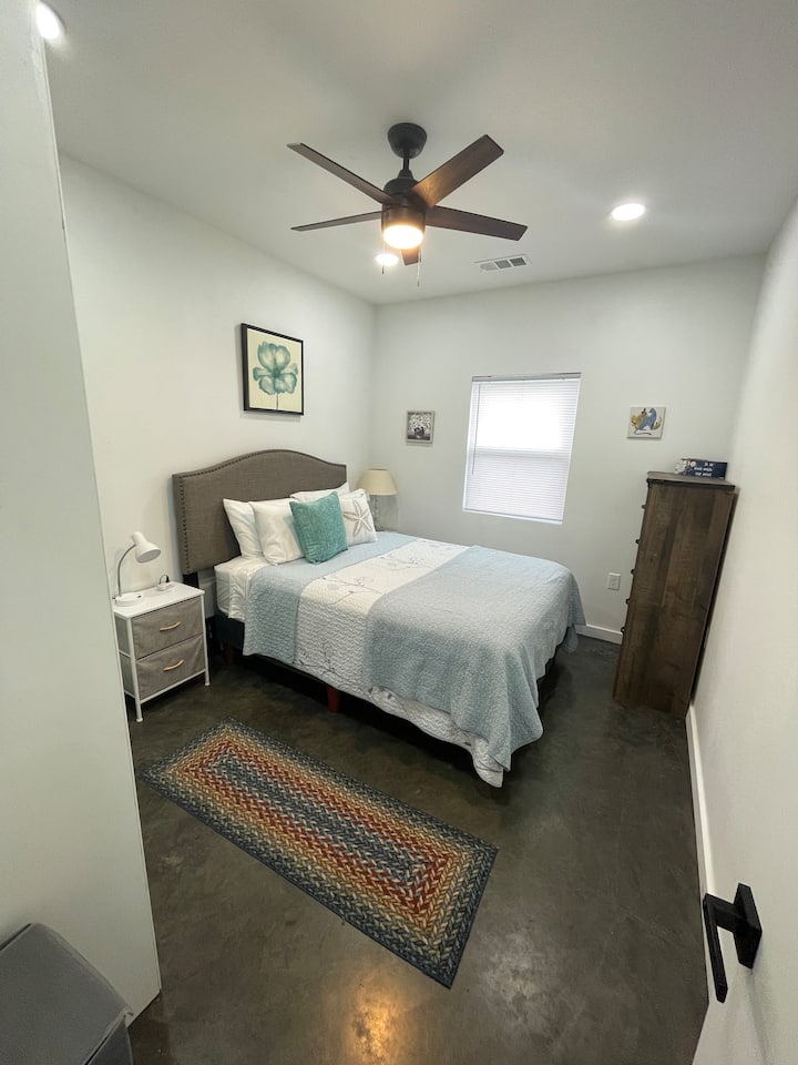 Удобна и ведра спална соба со брачен кревет (широк 150-179 см), мека постелнина и смирувачки декор дизајниран за да ви помогне да се опуштите и да спиете мирно. Вклучува осветлување покрај креветот, простор за складирање и тавански вентилатор за дополнителна удобност.