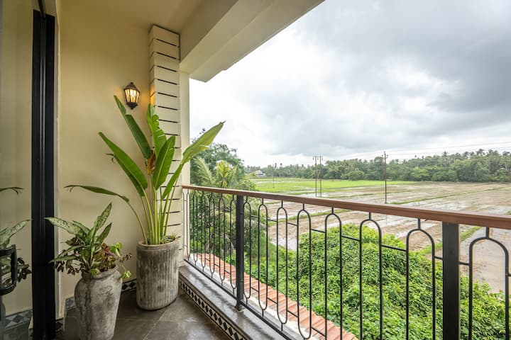 Unwind in a spacious bedroom overlooking lush green fields in Parra, North Goa, near the vibrant village of Assagao. Perfect for guests seeking a peaceful and luxurious Goa getaway.