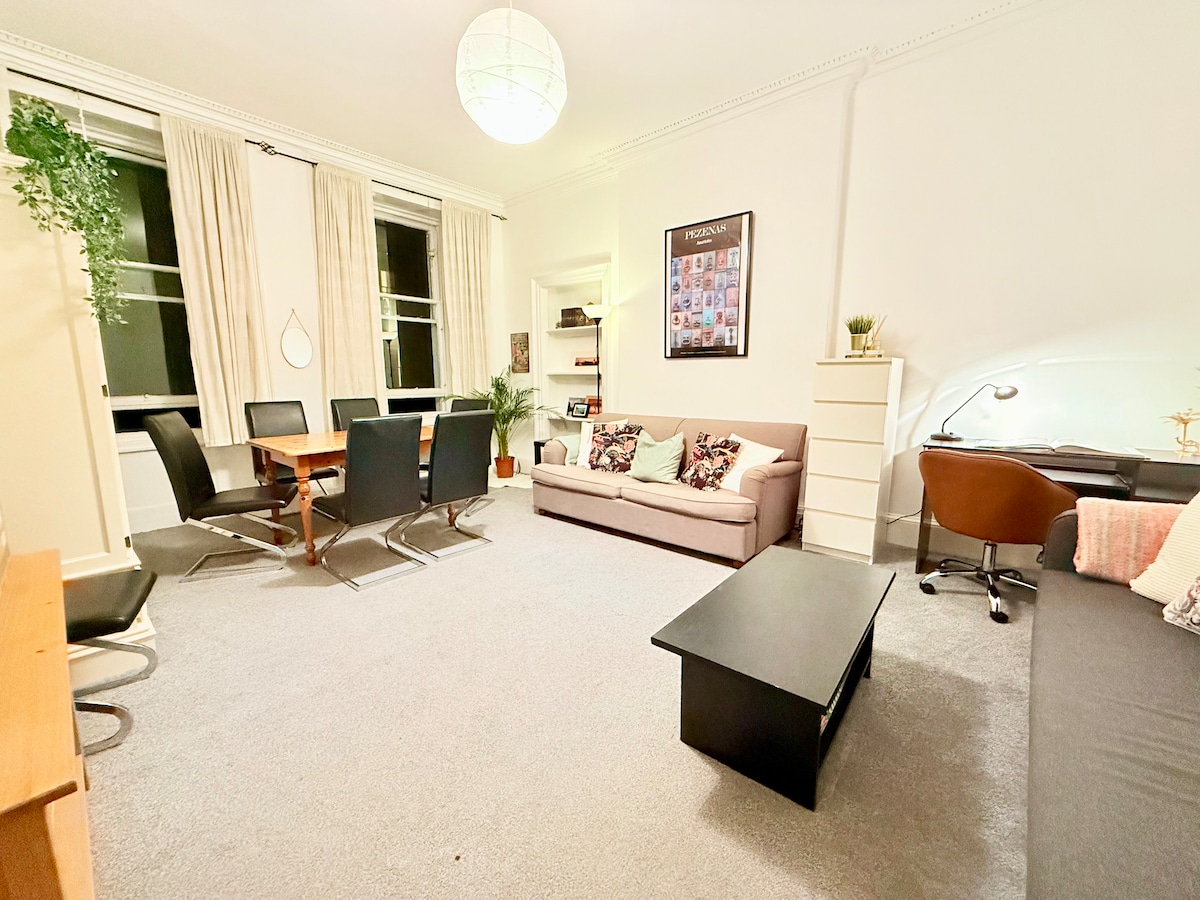 Მზიანი, სამხრეთით მდებარე მისაღები ოთახი ედინბურგის შუაგულში, სადაც ორი კომფორტული გასაშლელი დივანი და მყუდრო სასადილო სივრცეა. Ბუნებრივი სინათლით დატბორილი ეს იდეალური სივრცეა ქალაქის დათვალიერების შემდეგ დასვენებისთვის, ვახშმისა და განტვირთვისთვის.