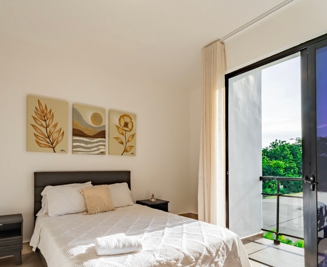 Chumba cha kulala chenye mwanga na starehe chenye ufikiaji wa roshani na mwonekano wa bustani. Toni laini, mapambo ya kifahari na mwanga wa asili huunda mazingira ya amani, yanayofaa kwa ajili ya kupumzika baada ya siku ya jua ufukweni au kwenye bwawa.