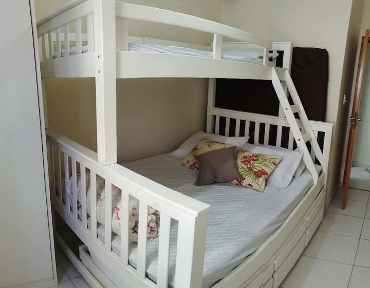 NO QUARTO TEMOS 1 TRELICHE COM 3 GAVETAS QUE TEM NO ALTO 1 CAMA DE SOLTEIRO, NO M EIO UMA DE CASAL E ABAIXO 1 DE SOLTEIRO + 1 COLCHÃO AVULSO DE CASAL, VENTILADOR DE TETO E 1 CRIADO PEQUENO DE 2 GAVETAS E CORTINAS.