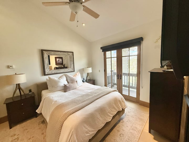 Dormitorio tamaño queen con baño completo, balcón privado, TV, armario y chimenea ubicados en el nivel principal.