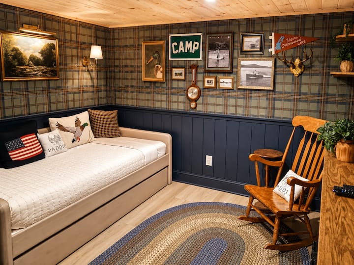Charming vintage camp-themed bedroom featuring a cozy daybed with trundle, rustic décor, and nostalgic cabin-inspired touches. Perfect for kids or guests, this inviting space offers comfort, character, and a fun retreat-like atmosphere.