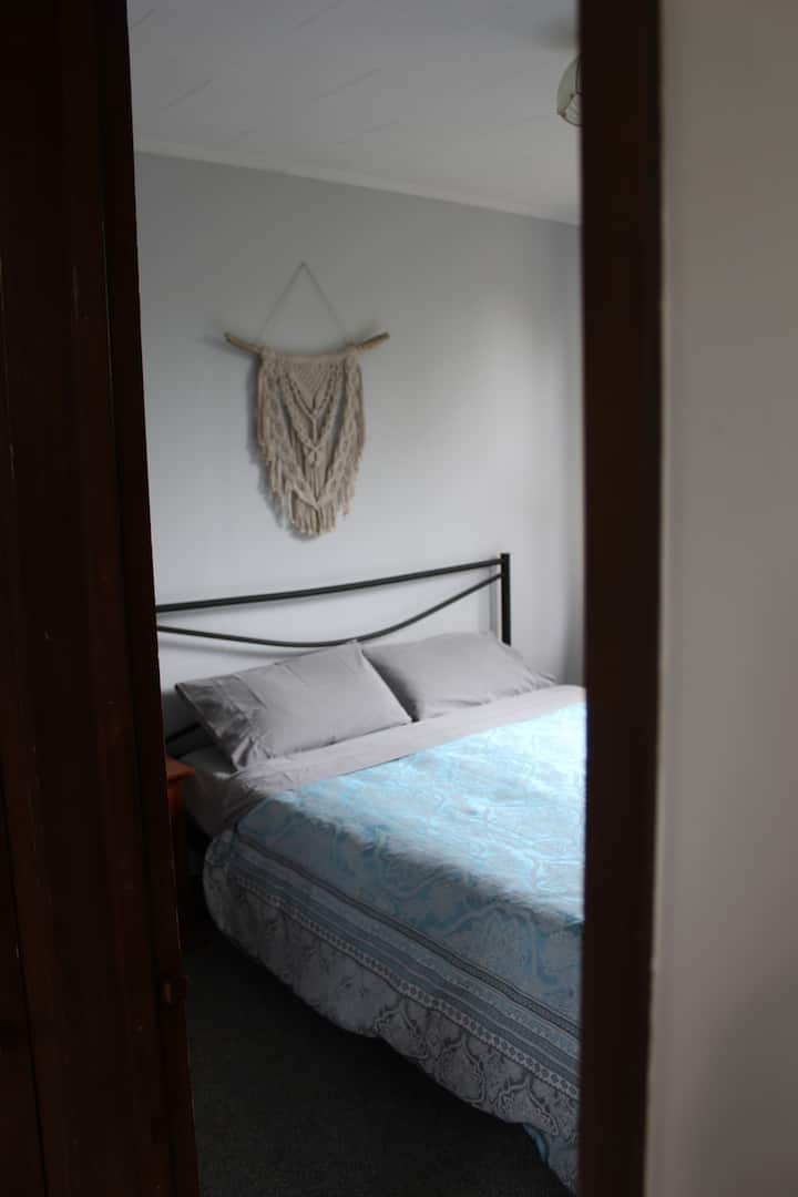 Lit double avec dressing et table de chevet.