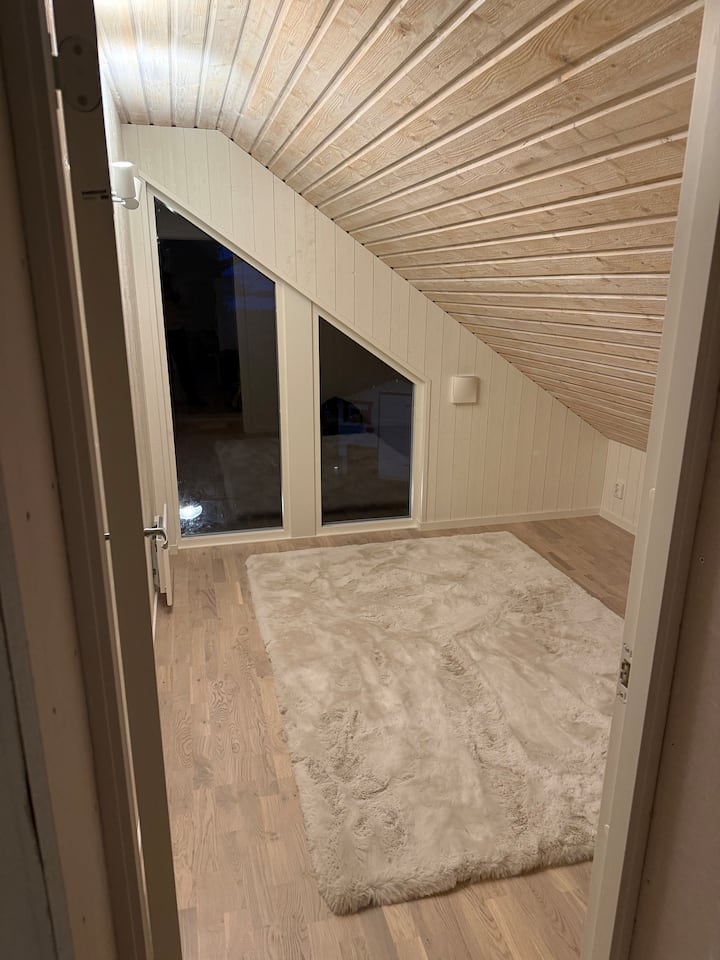 Spálňa s prístupom cez TV miestnosť na 2. poschodí. Jeden schod nadol a dostanete sa do spálne. Izba ešte nie je úplne zariadená, ale k dispozícii je matrac na podlahe, na ktorom sa dá spať.