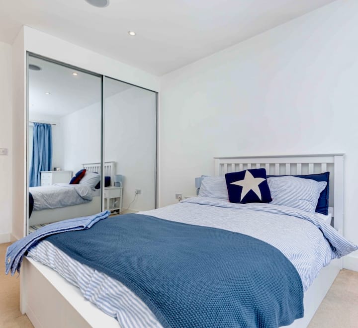 Bračni krevet s ormarom, radnim stolom i balkonom.
