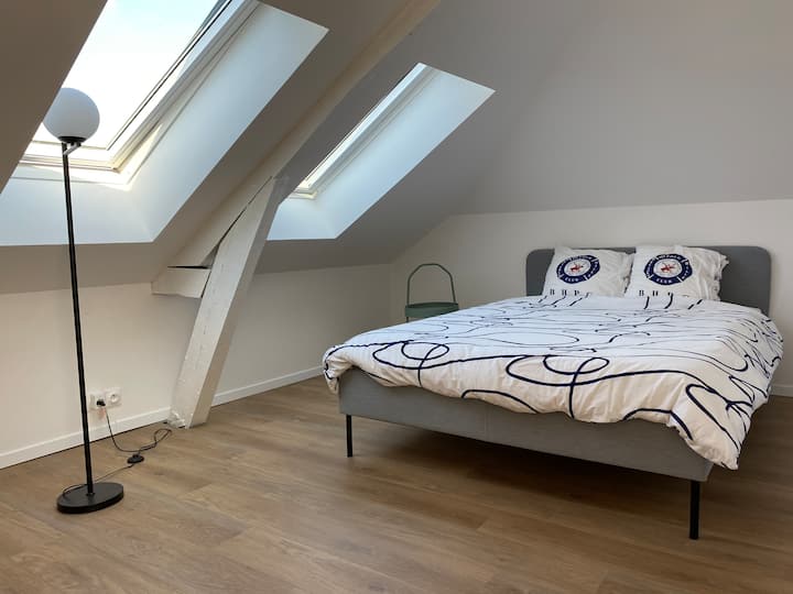 Habitación con cama doble en el segundo piso, con vistas a la calle