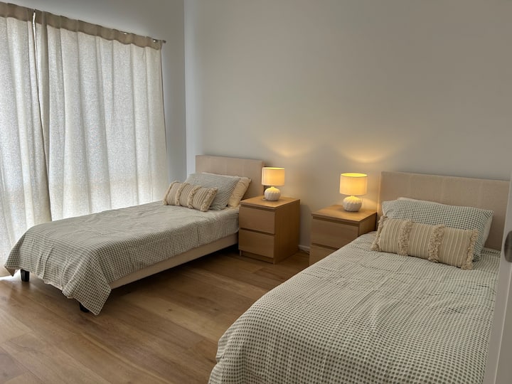 חדר שינה למטה 3 עם 2 מיטות יחיד ושידת מגירות 