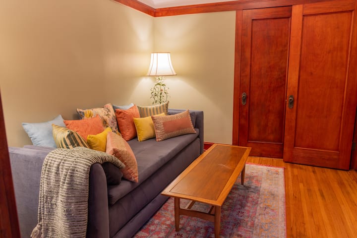 Framed by warm Prairie-style woodwork and historic details, the room blends vintage charm with modern comfort.