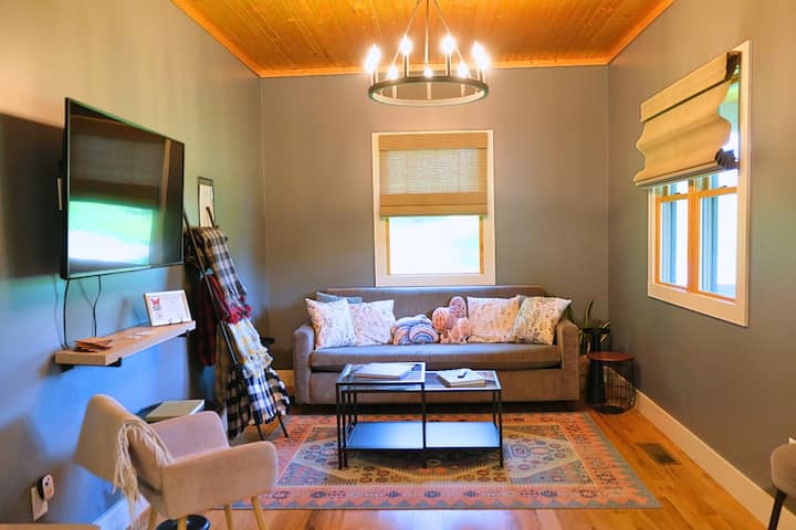 Chair, couch, coffee table, tv with shelf, quilt ladder, plant and side table