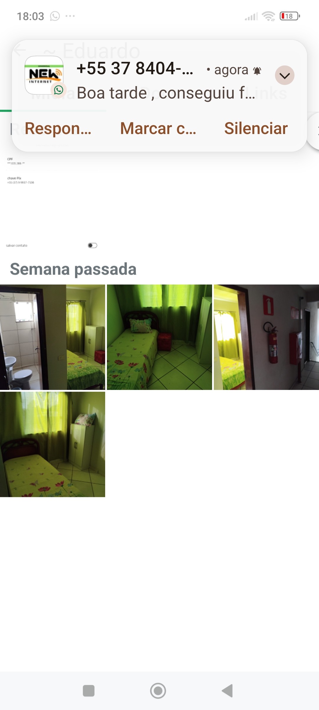 A single bed with a floral-patterned cover is positioned in a room adorned with vibrant green curtains. The room features a small closet and a personal bathroom area with essential amenities. Natural light is filtered softly through the curtains.