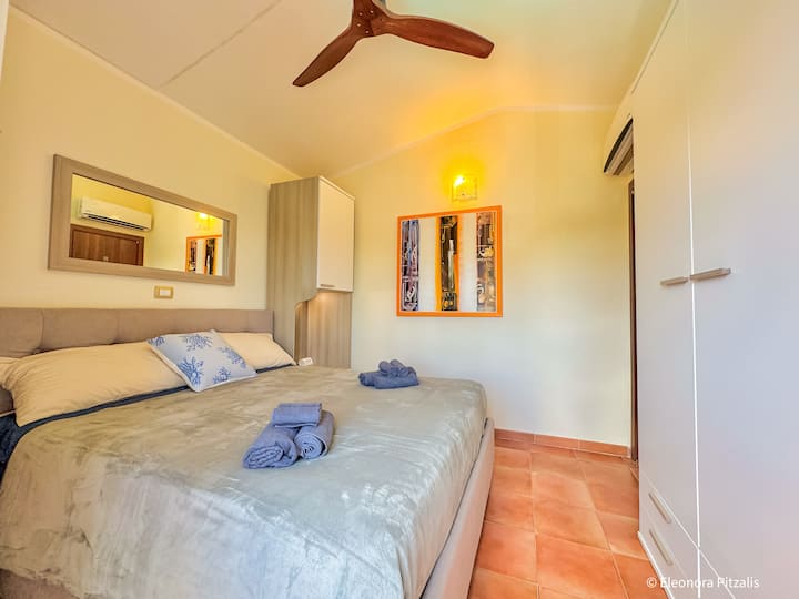 Chumba cha watu wawili chenye mwanga na milango ya Kifaransa kuelekea kwenye roshani, mwonekano wa bwawa la kujitegemea na makabati makubwa ya kuhifadhi kila kitu kwa urahisi. 