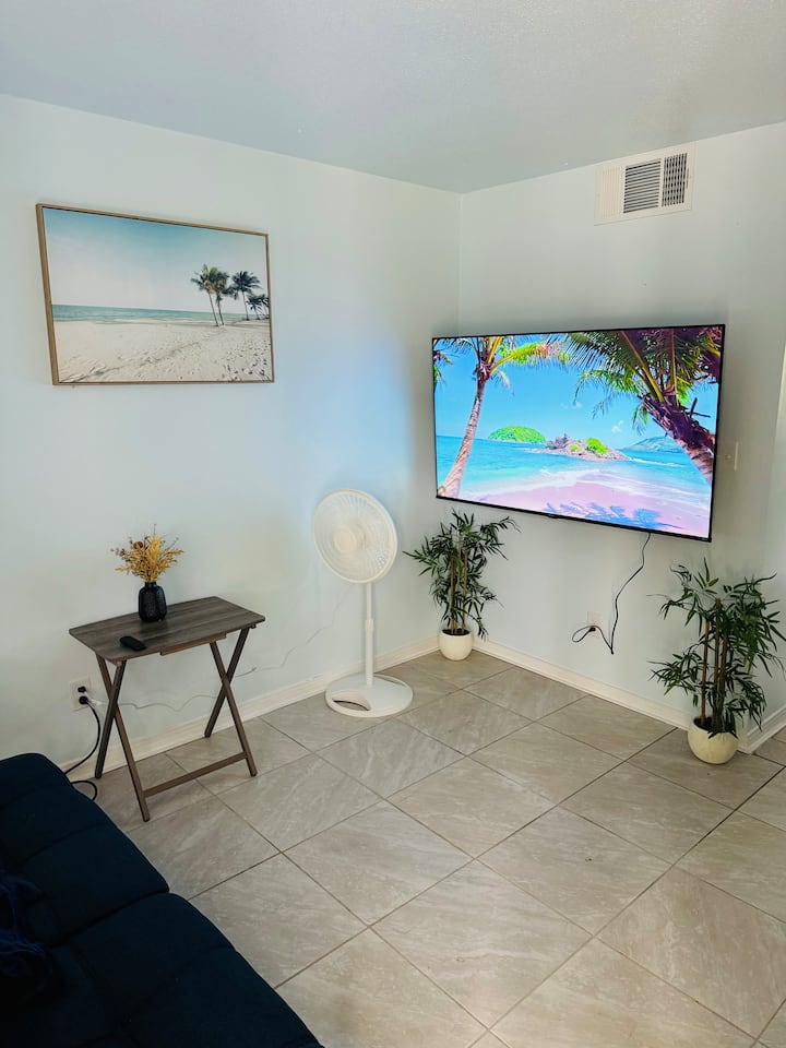 Living room with 60" smart Roku tv and small desk