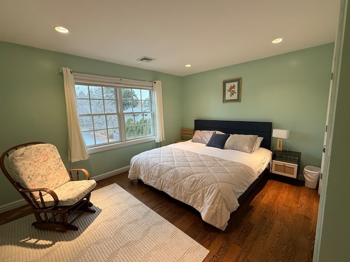 La cama KING NUEVA tiene un edredón grueso, y también se proporciona un edredón extra delgado para que lo uses en cualquier momento si sientes frío.  Tiene una mecedora y un armario grande a la derecha.