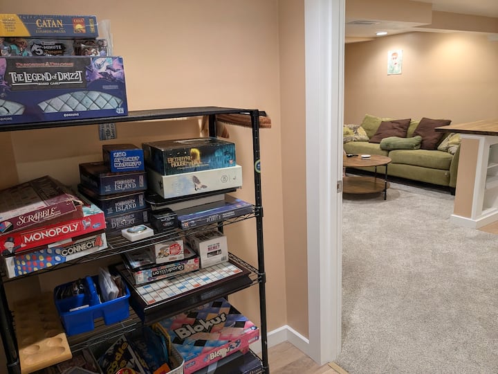 Estante de juegos de mesa justo fuera del estudio, lleno de clásicos y favoritos: Catan, Scrabble, Monopoly, D&D y muchos más. Sírvete.