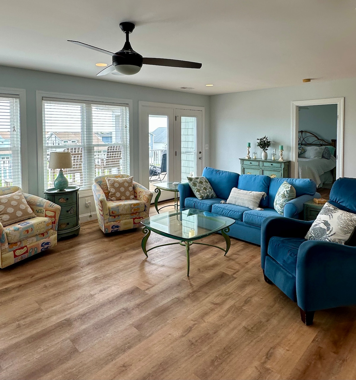 Sala de estar superior con TV de 85 pulgadas, wet bar y muchos asientos.