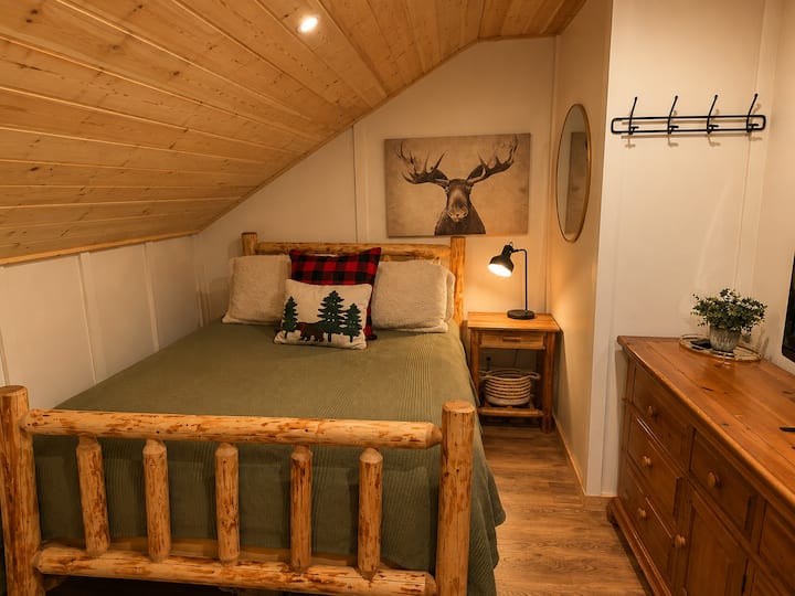 Cama tamaño queen y TV en la habitación, con comodidad para dos huéspedes.