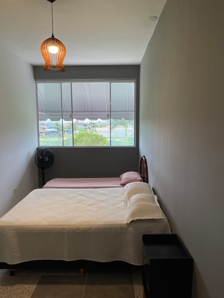 Chumba cha kulala chenye starehe, chenye kitanda cha kifahari na vitanda viwili vya mtu mmoja, matandiko na mito ya msingi. 