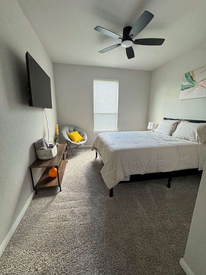 Dormitorio en el primer piso equipado con una cama tamaño queen y un televisor de pantalla plana de 50".