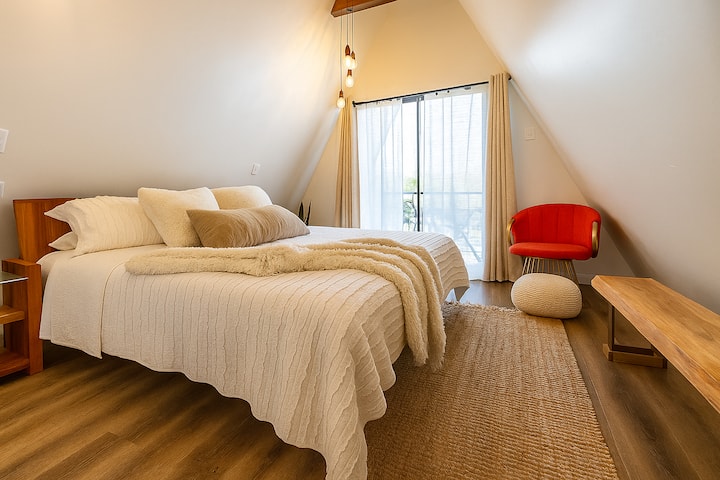 Tucked away upstairs, this intimate loft bedroom is a quiet escape bathed in warm light and the most comfortably bed—an elevated space designed for the most peaceful rest.