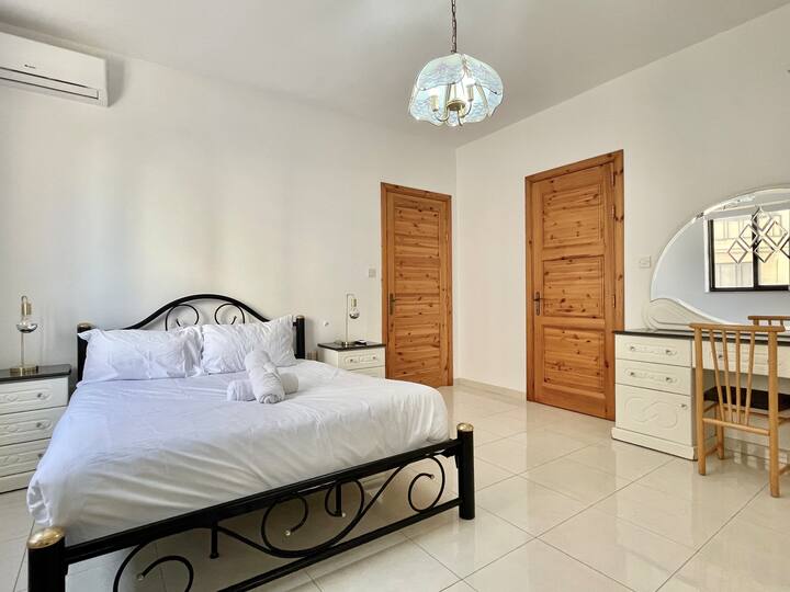 Zink weg in het comfort van een kingsize bed in deze ruime slaapkamer — een rustgevend toevluchtsoord met zachte verlichting, elegante accenten en meer dan voldoende ruimte om te ontspannen. 