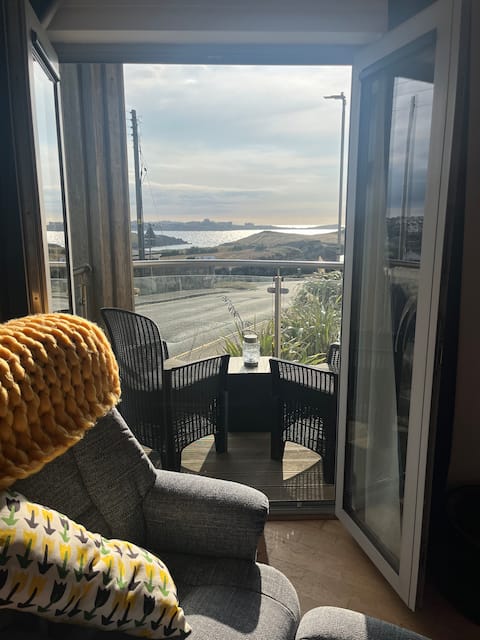 Balcony chairs and table looking out over the coast from the apartment