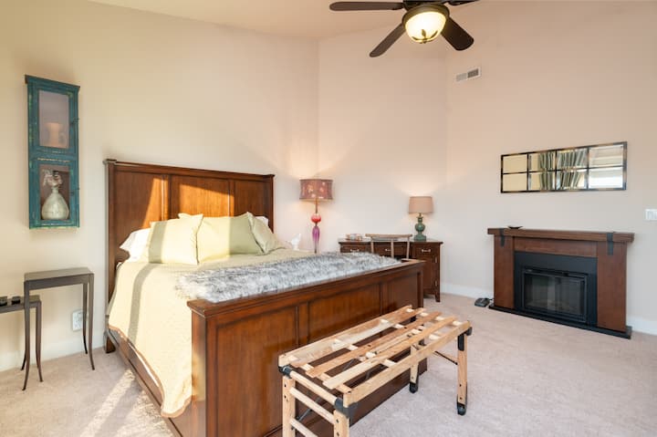 سرير كوين في غرفة النوم الرئيسية مع مدفأة كهربائية