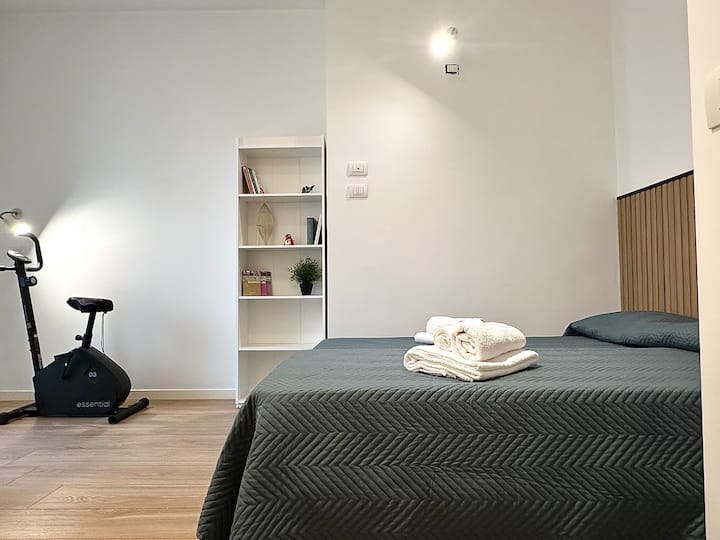 Голема спална соба со два единечни кревета, голема гардероба и директен пристап до балконот со простор за перење и велосипед за вежбање, идеална за удобен престој со функционални и добро организирани простори.