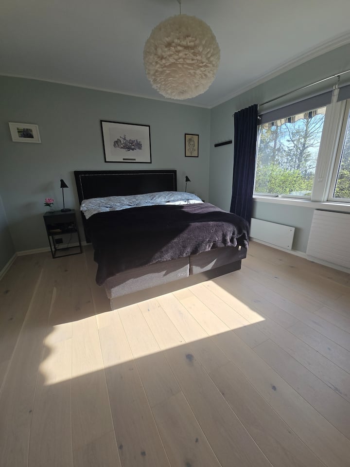 Მთავარი საძინებელი ზემოთ, ფართო სივრცით, დიდი საწოლი სინათლით და მაგიდა ორივე მხრიდან. Ფანჯრები, რომლებიც წყნარ ბაღსა და ტყეს აწყდება