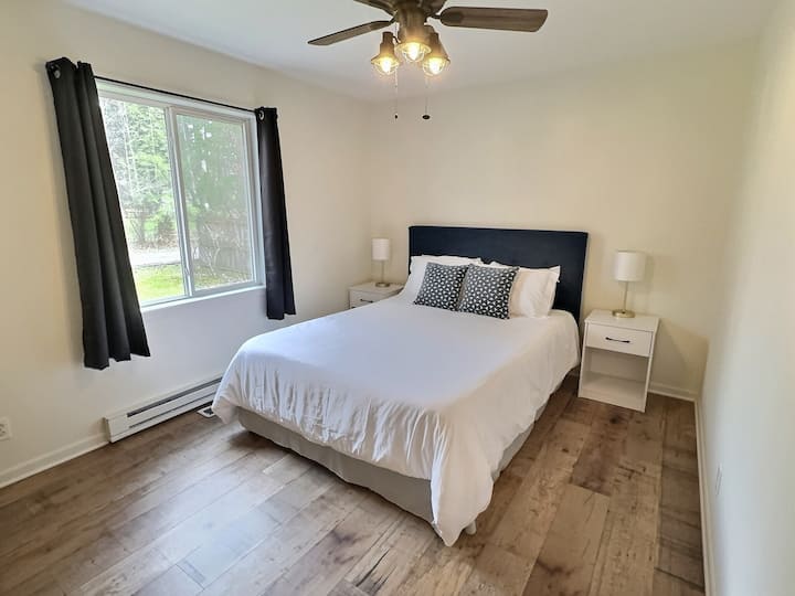 Spacious secondary bedroom with queen size bed, newly added nightstands and lamps with USB ports for additional charging. Here you will also find a desk, mirror and closet.