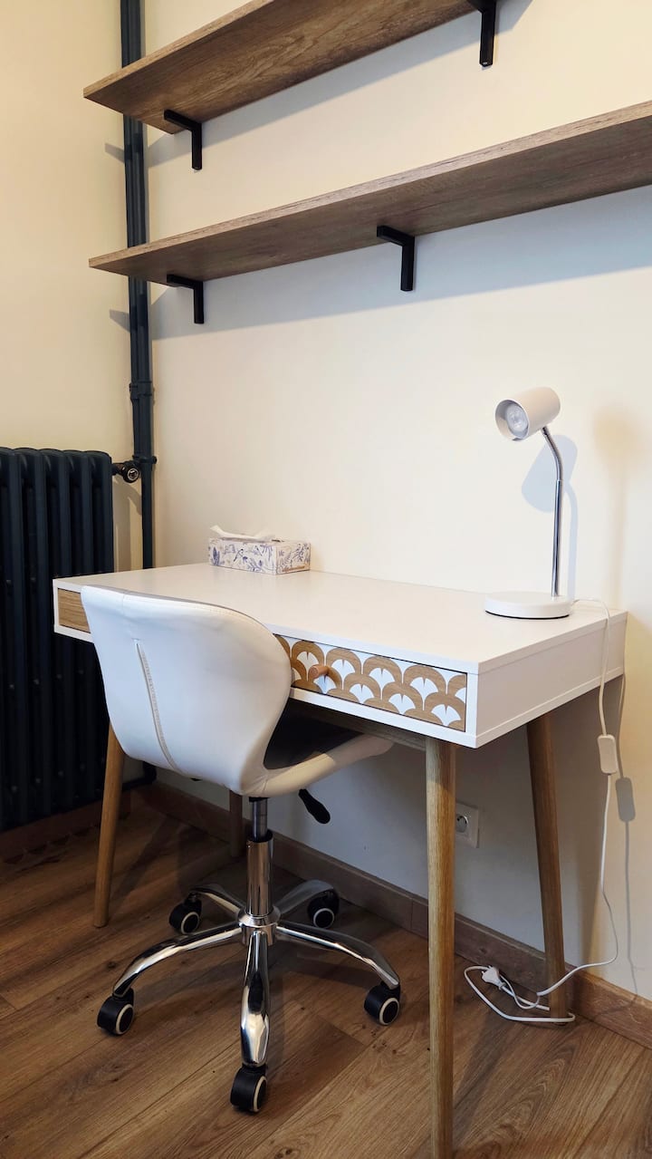 Chambre avec bureau et chaise, parfait pour télétravail ou étude.