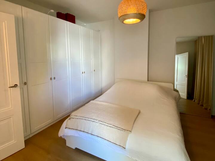 La chambre principale avec salle de bain attenante dotée d’une baignoire, d’une douche et de toilettes.