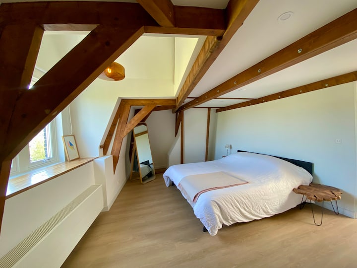 Au quatrième étage de notre maison sur le canal, face au canal, avec des éléments classiques et des poutres en bois d’origine.