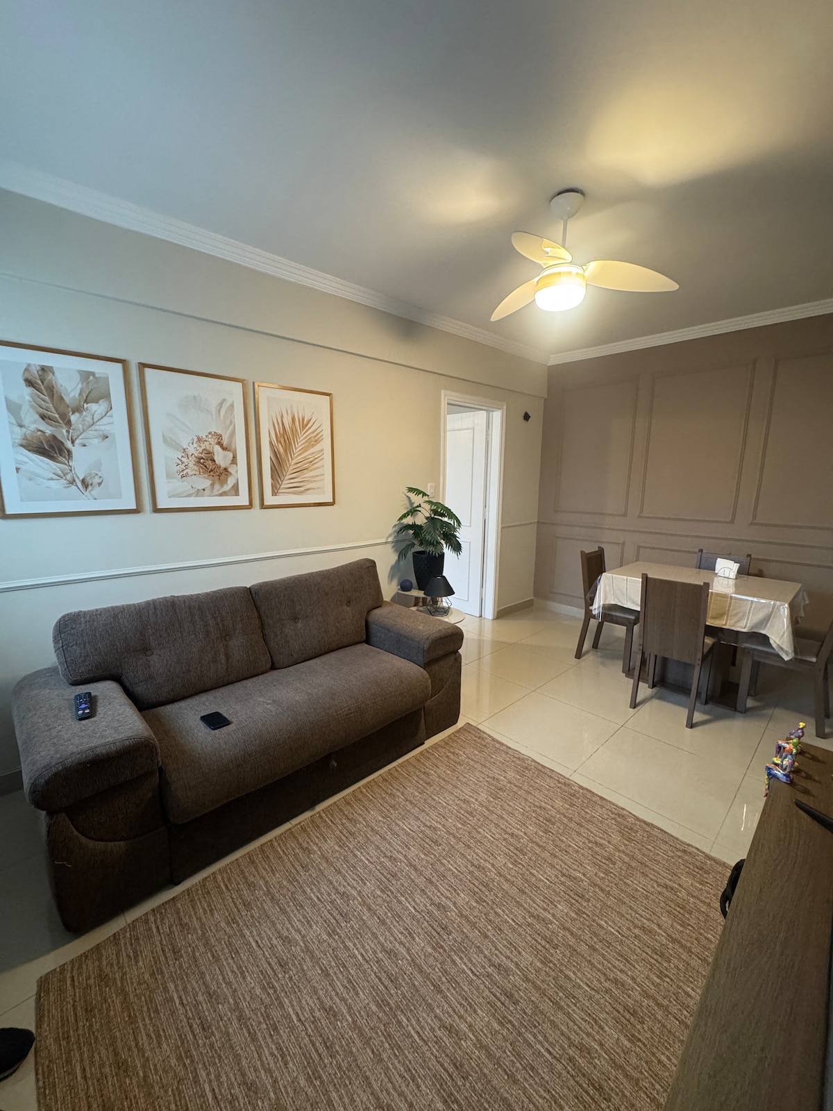 Уютна всекидневна с разтегателен диван и 42-инчов телевизор със стрийминг (Netflix, Prime Video и Globoplay) и Wi-Fi, има вентилатор на тавана.