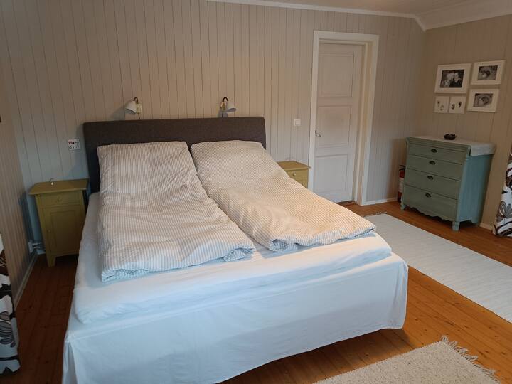 Dhomë gjumi me një krevat dopio 180 cm të gjerë.