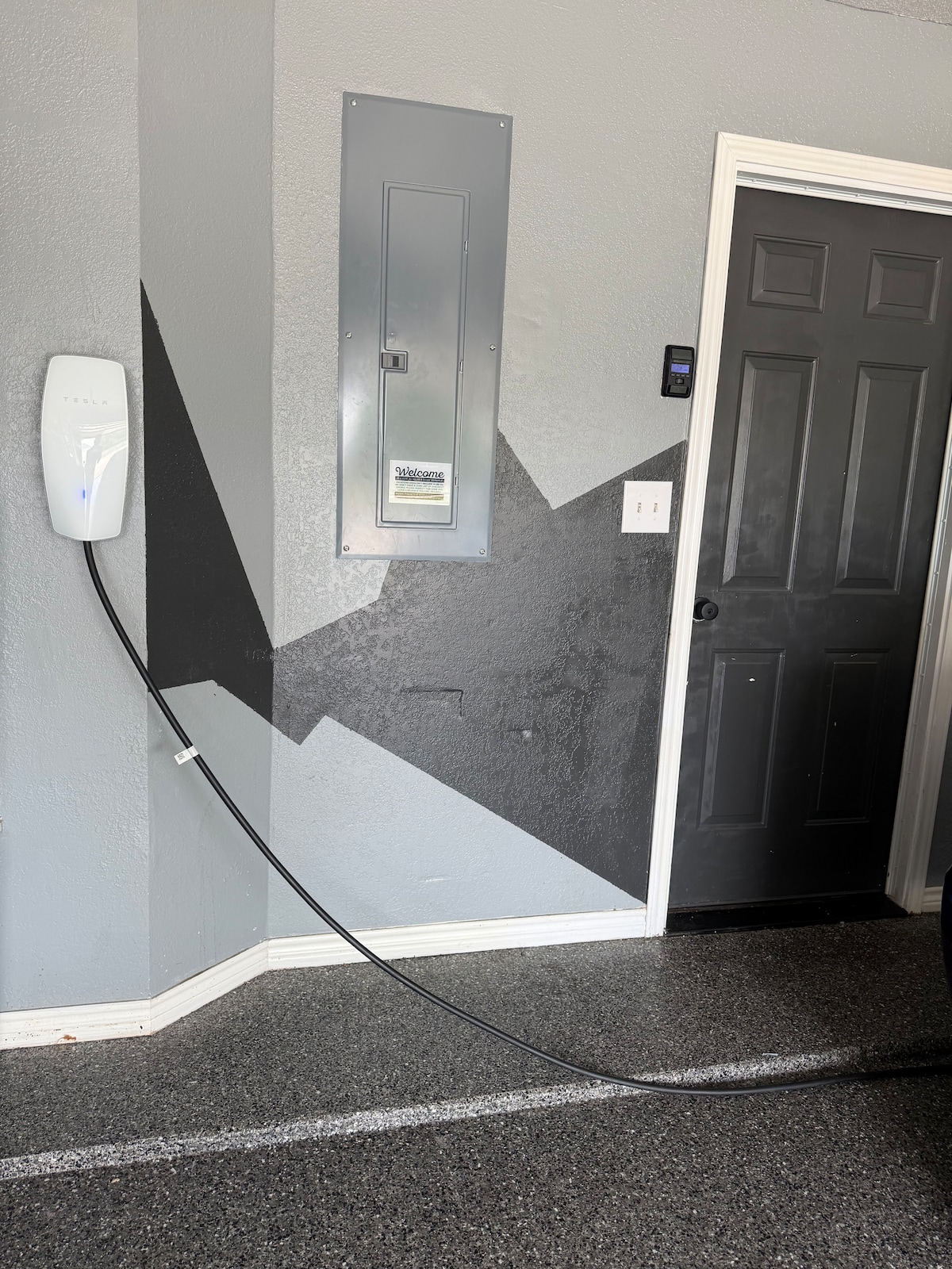 Attached 2-car garage featuring a wall-mounted EV charger so you can park securely indoors and charge overnight.