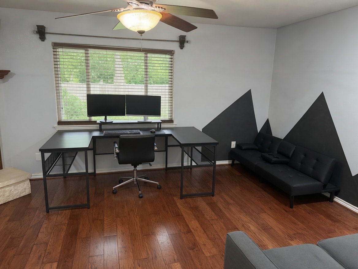 Dedicated remote-work office with dual monitors, wide desk, Ethernet connection, fast Wi-Fi, and lounge couch—ideal for TDY telework or PCS paperwork.