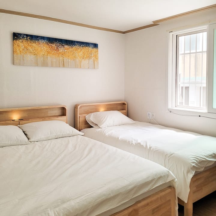 Seoul Stay Seongsu Bedroom 2 არის სივრცე, რომელიც საგულდაგულოდ არის დაყენებული ორადგილიანი საწოლით და სუპერ ერთადგილიანი საწოლით სუფთა ბამბის თეთრეულით, რაც კომფორტს ანიჭებს უპირატესობას. Ფანჯრებიდან მზის რბილი სინათლე ჩნდება და მას განსაკუთრებულ თავშესაფრად აქცევს, სადაც ოჯახის წევრებსა და მეგობრებს ერთად თბილი და მყუდრო დროის გატარება შეუძლიათ.