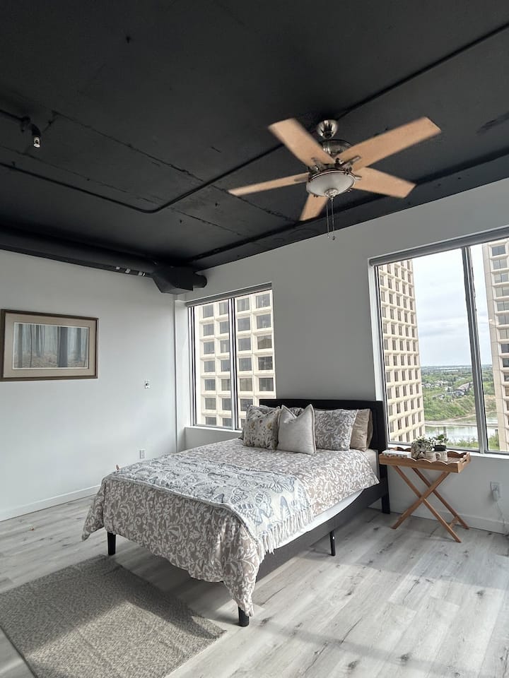 Спалня: стилни завивки и просторни прозорци ви канят да се отпуснете с изглед към града!