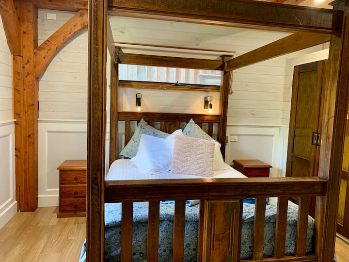 Chumba kikuu cha kulala kimekamilika na kitanda cha kifahari chenye nguzo nne.