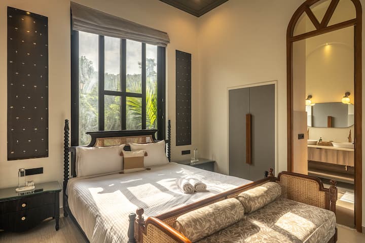 Enjoy a restful stay in a modern bedroom with a king-size bed, ensuite bathroom, air conditioning, and safe. A comfortable retreat in a luxury vacation villa in North Goa.