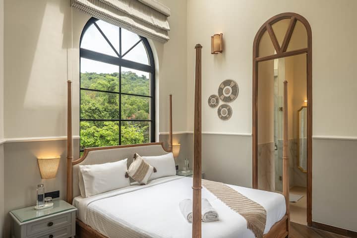Recharge in a beautifully designed bedroom featuring a king-size bed, private ensuite bathroom, air conditioning, and a safe. Your ideal North Goa villa getaway.