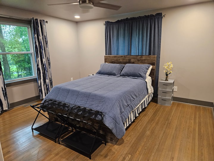 Master bedroom with gorgeous views to back property. There are three bedrooms and three bathrooms, with the primary suite on the main level and junior suite upstairs, both with ensuite bathrooms and black-out curtains for daytime sleepers.